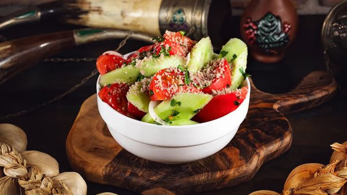 Cucumber tomato salad with walnuts - Georgian dish at Tbilisuri Ezo restaurant in Tbilisi }}