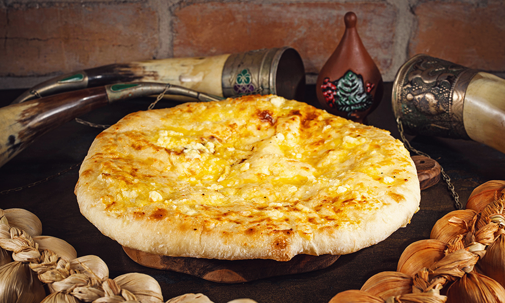 Megruli Khachapuri - Georgian dish at Tbilisuri Ezo restaurant in Tbilisi }}